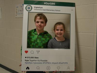 Happy brother and sister pose for a picture in the Tweet frame.