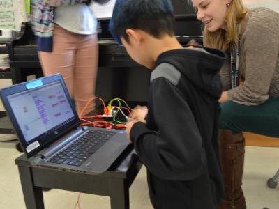 Ms-Cartwright-and-boy-reviewing-his-scratch-coding-and testing-out-makey-makey
